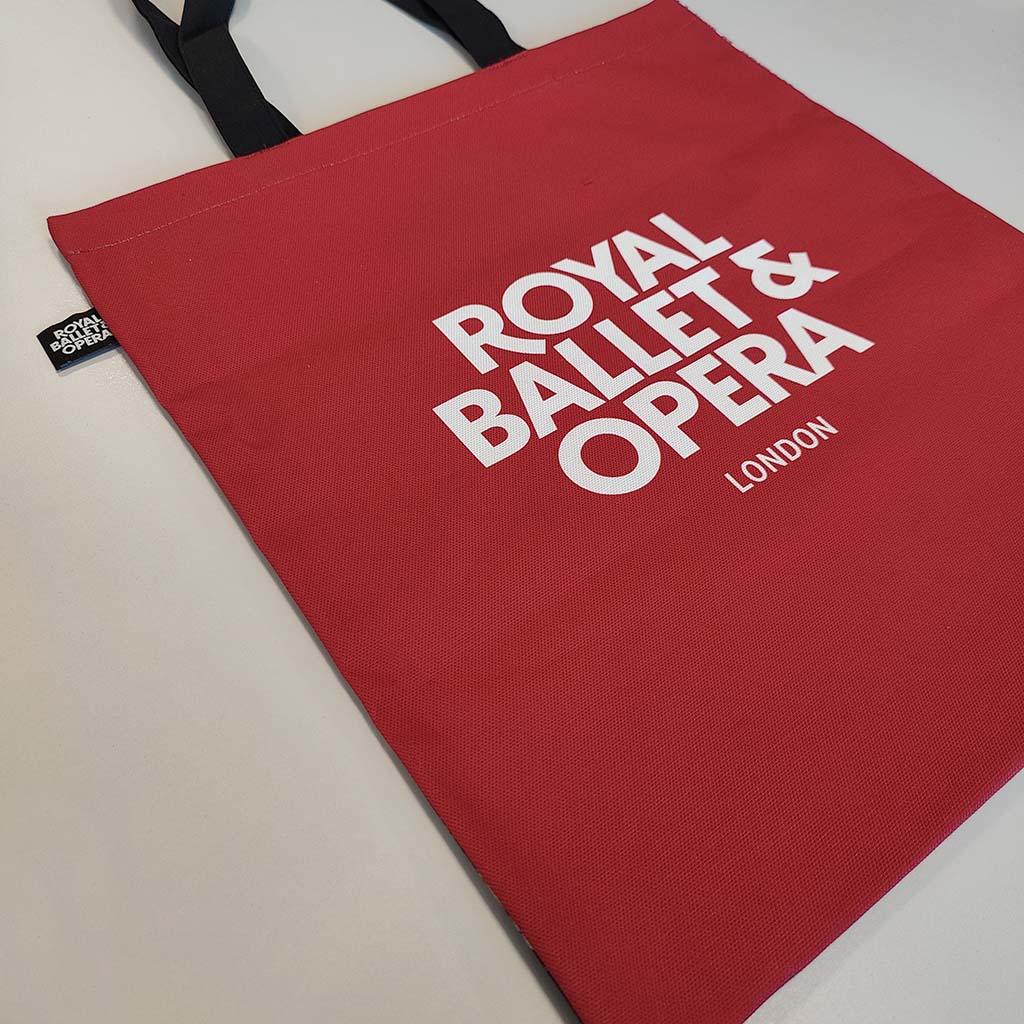 A tote bag featuring a painting of the Main Stage auditorium, capturing the iconic red velvet curtains, gilded frescoes, a glimpse of the orchestra, and the magnificent ceiling dome on a white background