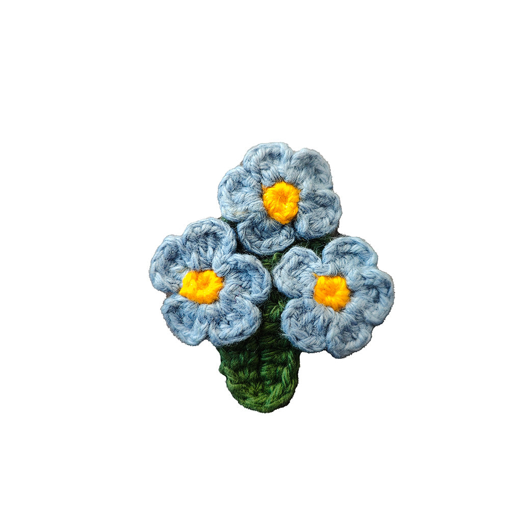 colourful crochet flower brooch on a white background