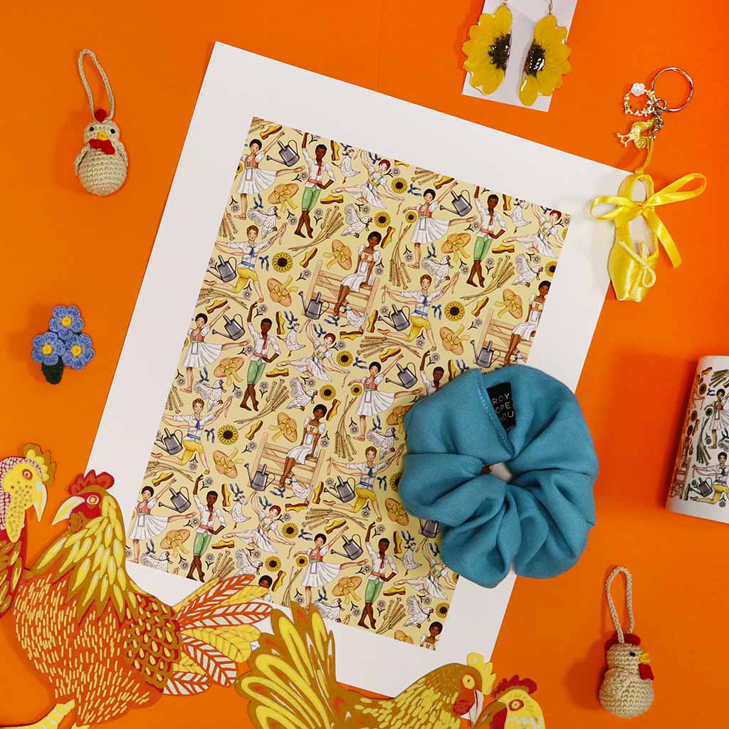 Illustrated print of La Fille mal gardee ballet pattern with dancers, sunflowers, and farm tools on a yellow background