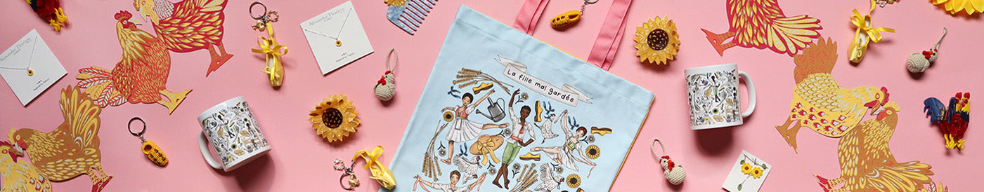 selection of ballet themed products on a pink background, including a tote, keyrings, mug, comb, jewellery, hair accessories and chicken garland