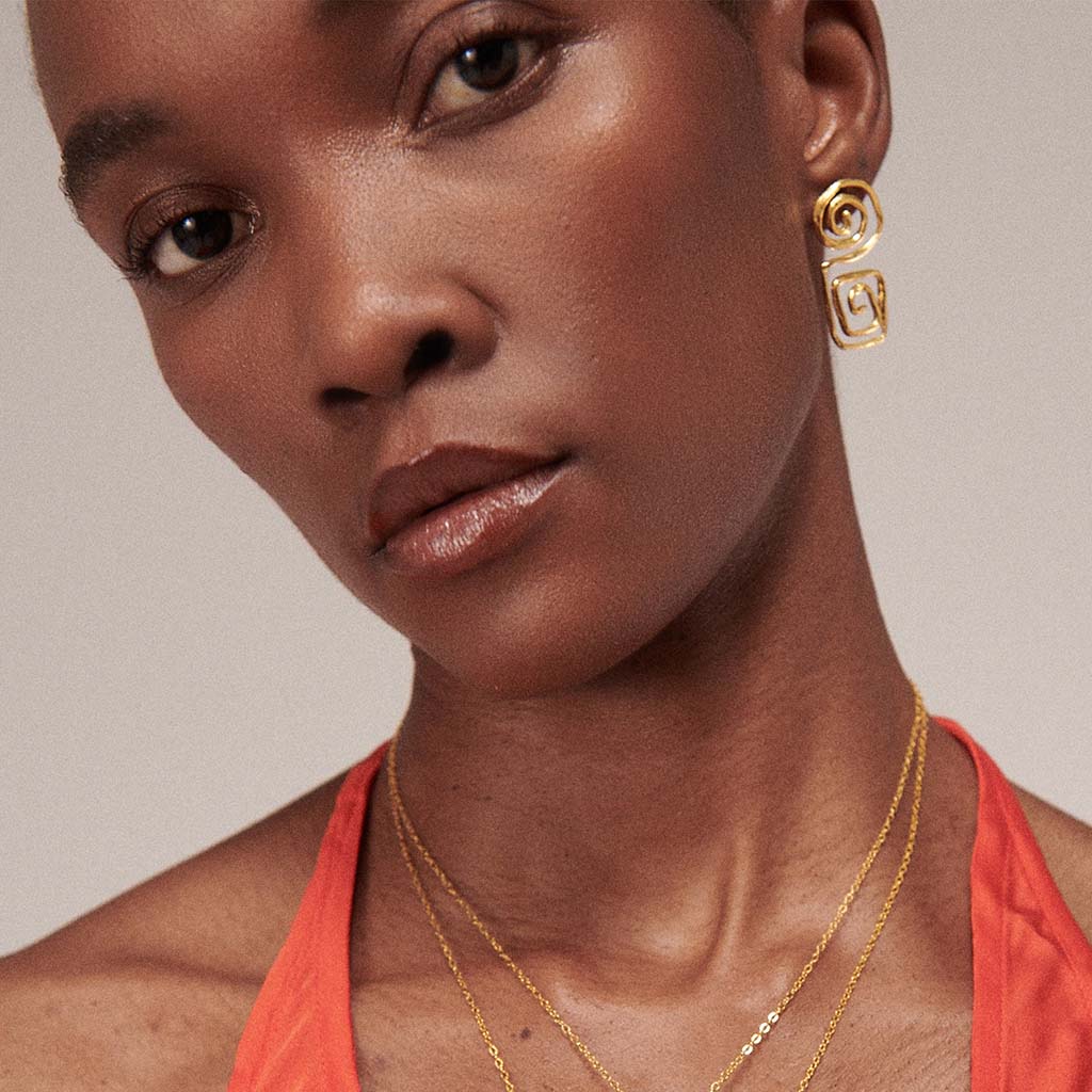 Gold spiral earrings on a white background