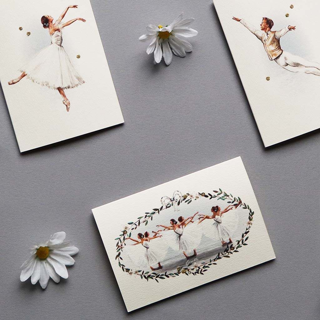 Elena Deshmukh greeting cards with ballerina designs from Giselle on a gray surface with daisies.