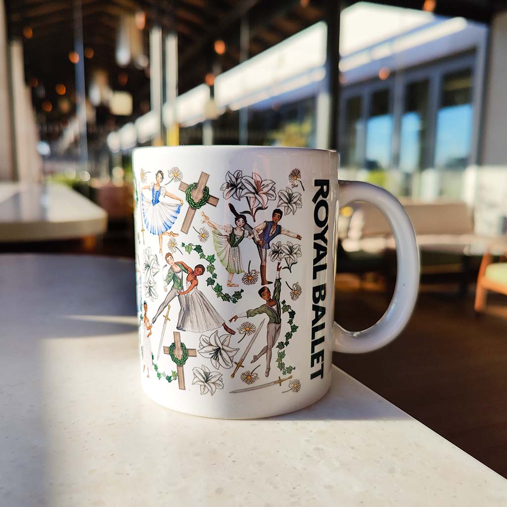 white mug with giselle ballet illustrations on a marble surface