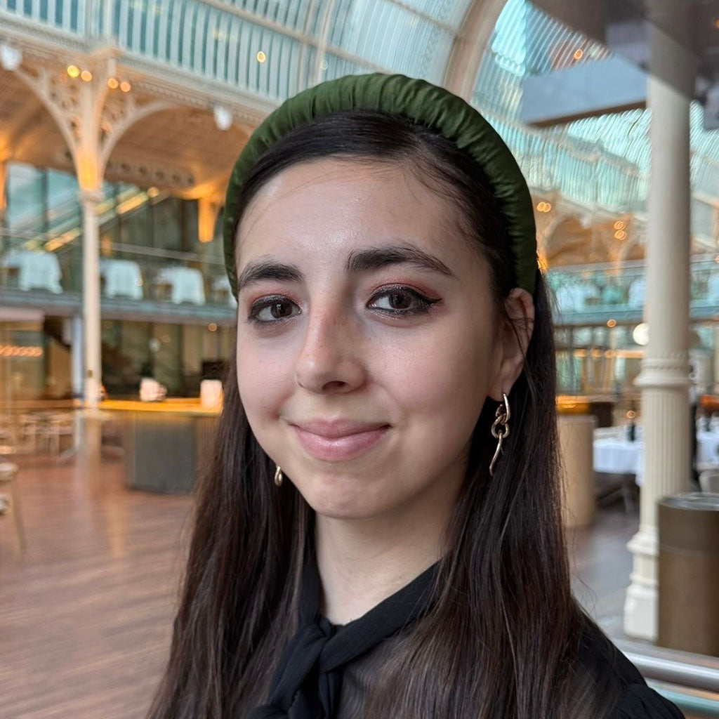 model wears an olive green padded headband in the Paul Hamlyn Hall at the Royal Opera House