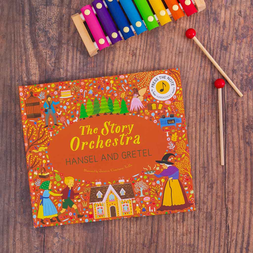 Children&#39;s book &#39;The Story Orchestra Hansel and Gretel&#39; with xylophone on a wooden surface