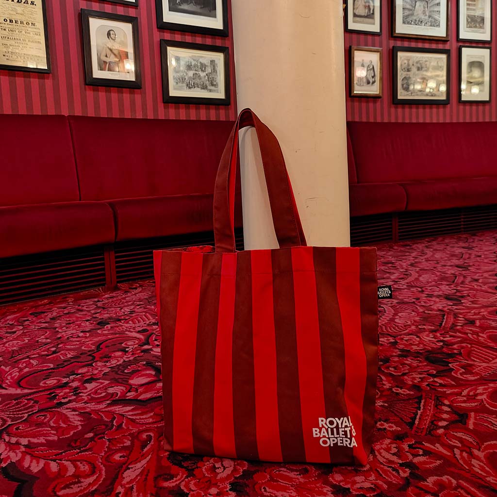 Striped view of the heritage tote by a column with striped wallpaper behind