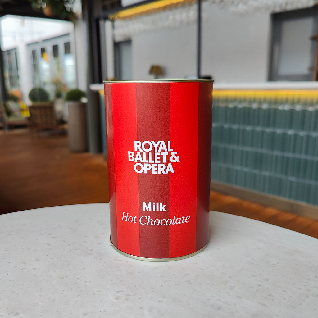 Red can of Royal Ballet &amp; Opera milk hot chocolate on a table with a blurred background