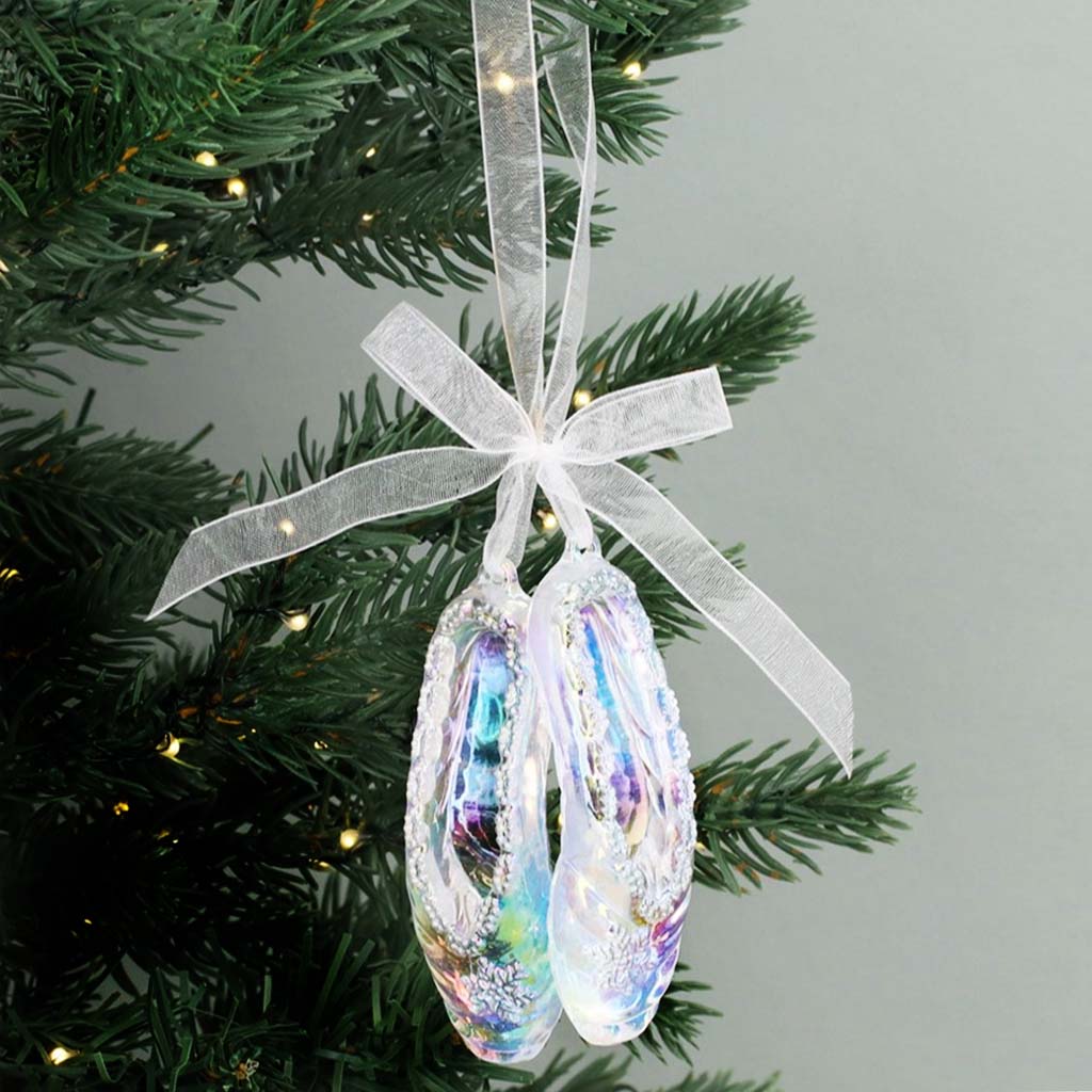 Iridescent acrylic ballet shoe decoration with a bow on a white background