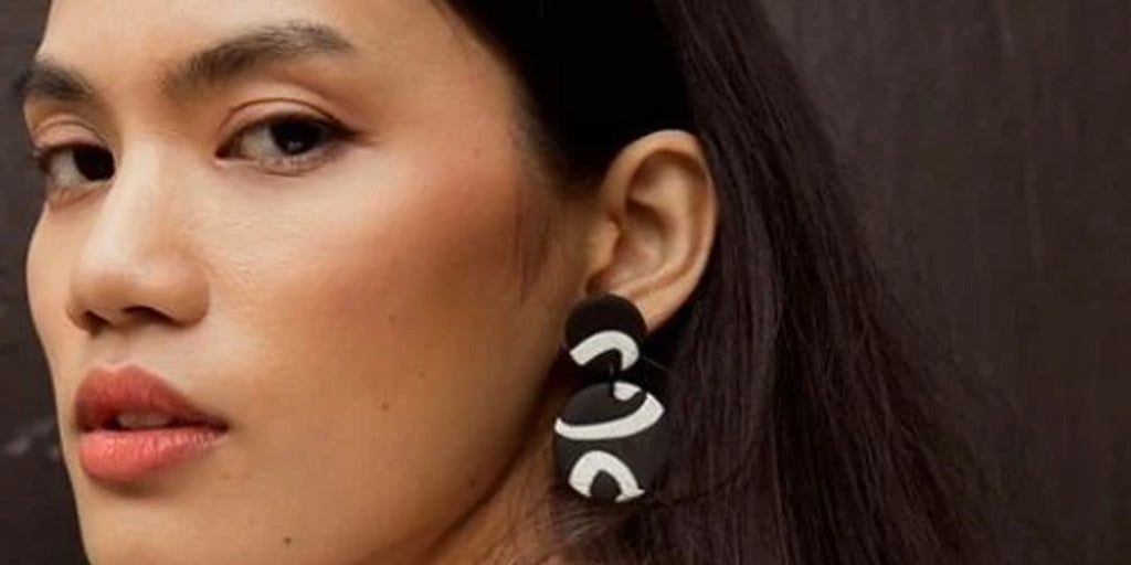 model wearing a pair of black and white songline earrings