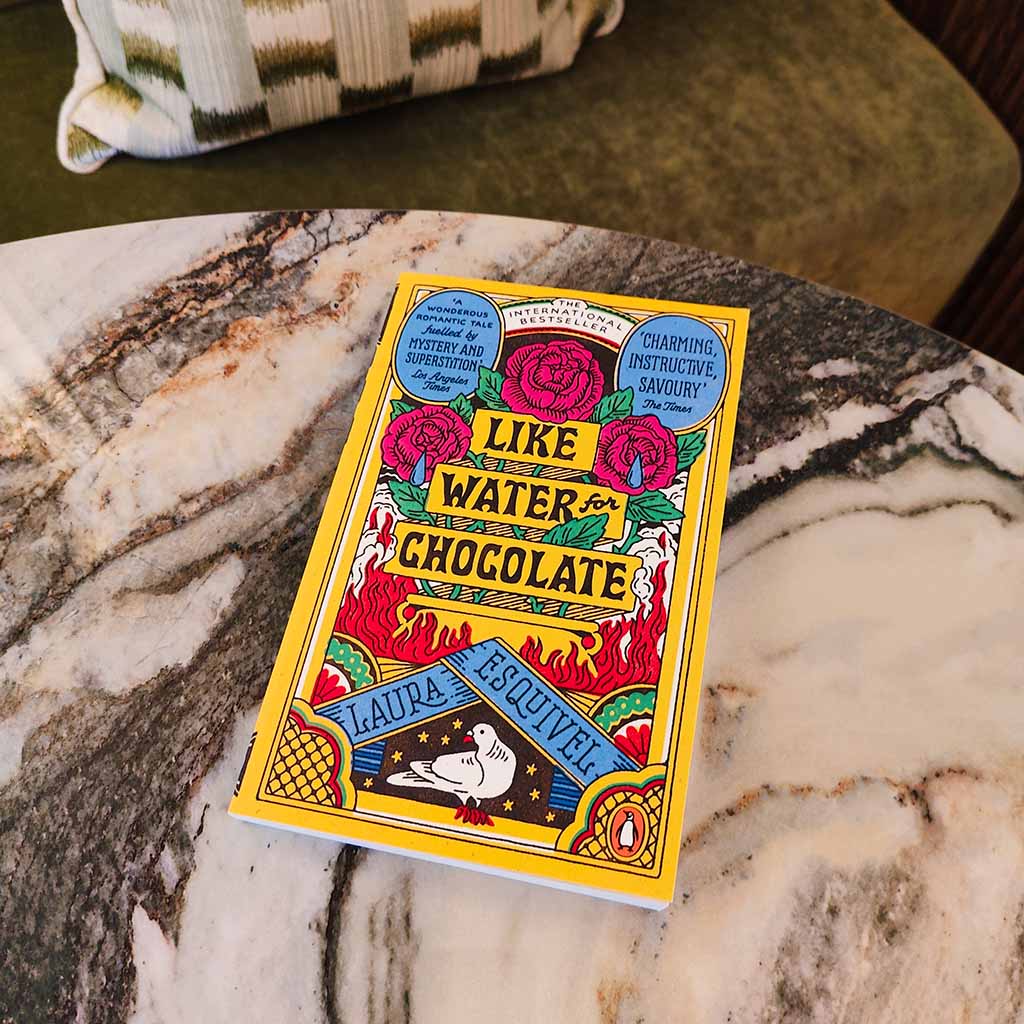 Book titled &#39;Like Water for Chocolate&#39; by Laura Esquivel on a marble surface.