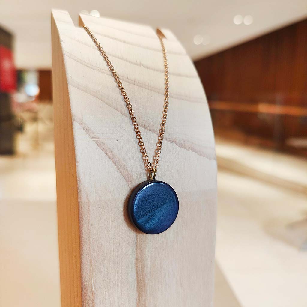 Magic Flute Full Moon Necklace on wooden stand in foyer