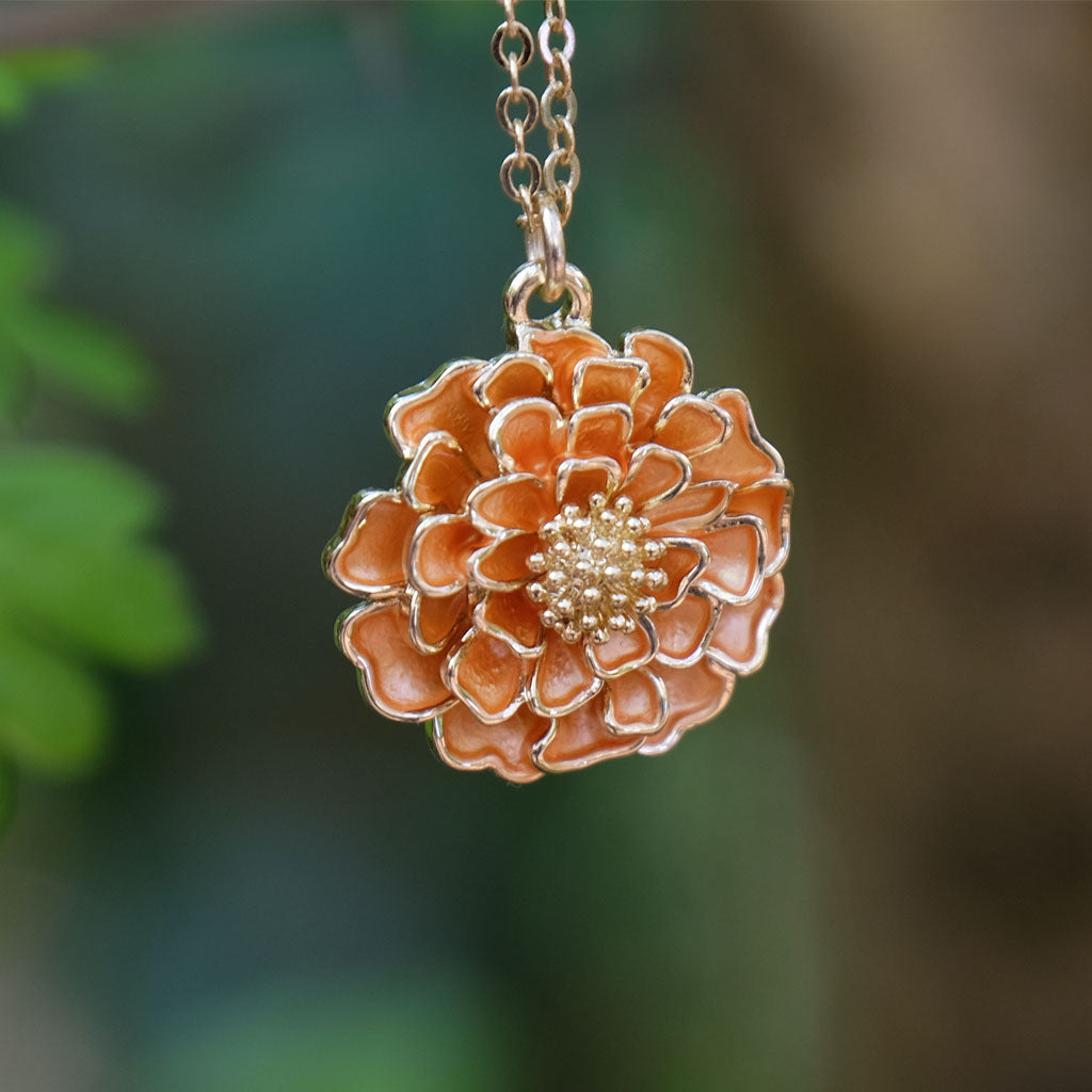 Floral pendant necklace with a blurred green and brown background