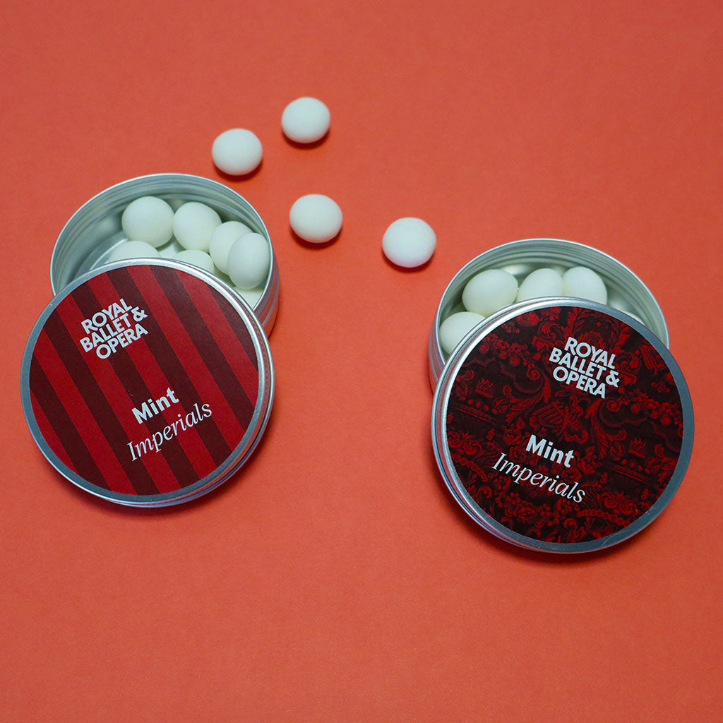 Two open tins of Royal Ballet &amp; Opera Mint Imperials on a red background