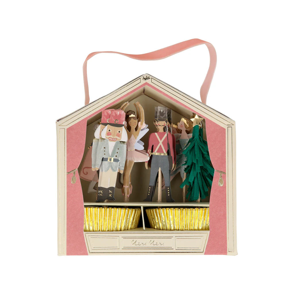 Nutcracker themed cupcake kit in a decorative house-shaped box with Nutcracker figurines and a tree with gold cake cases on a white background
