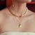 Gold necklace with a face pendant on a white background