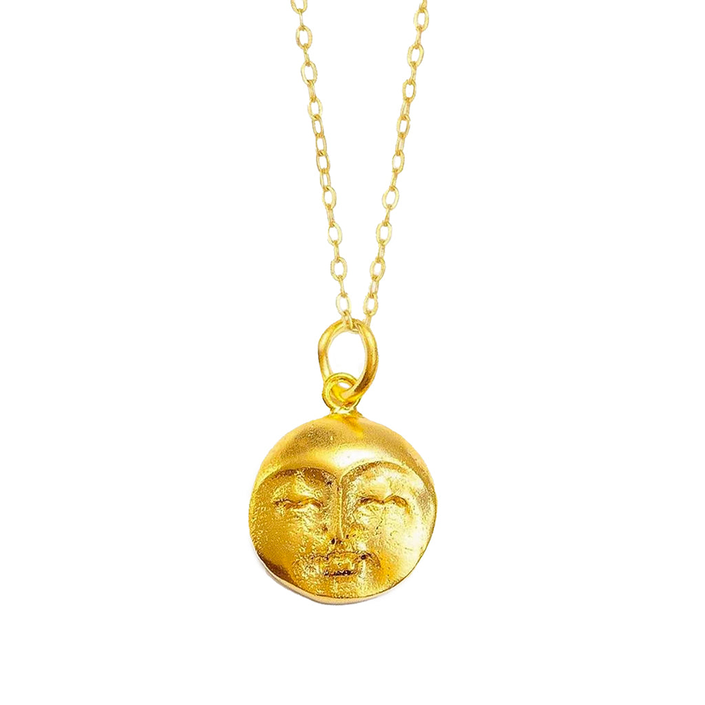 Gold necklace with a face pendant on a white background