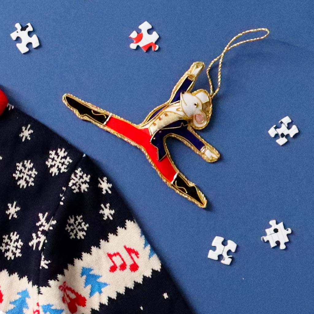 mouse king decoration on a blue background with jigsaw pieces and part of a christmas jumper