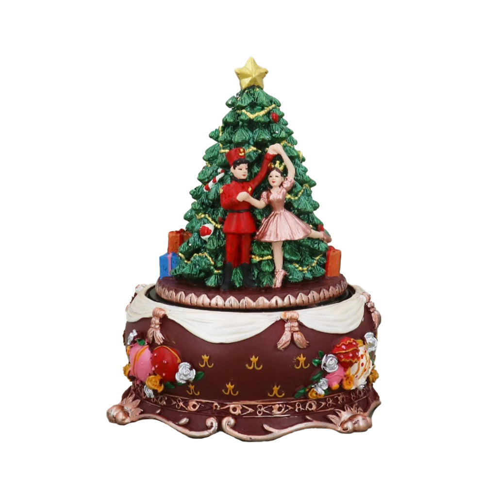 A Christmas-themed music box figurine featuring a dancing couple under a decorated Christmas tree with a gold star on top, set on an ornate round base with festive details.