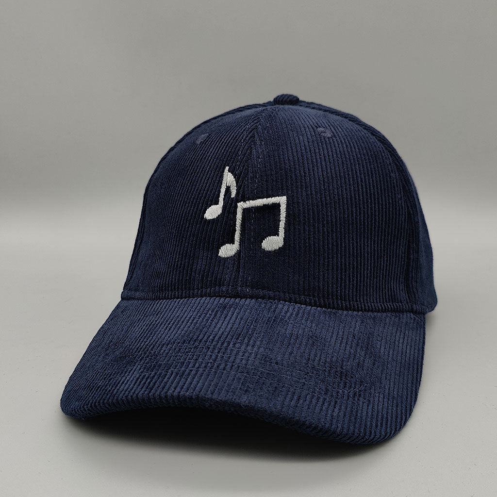 Navy blue cord cap with a grey music note design on a gray background