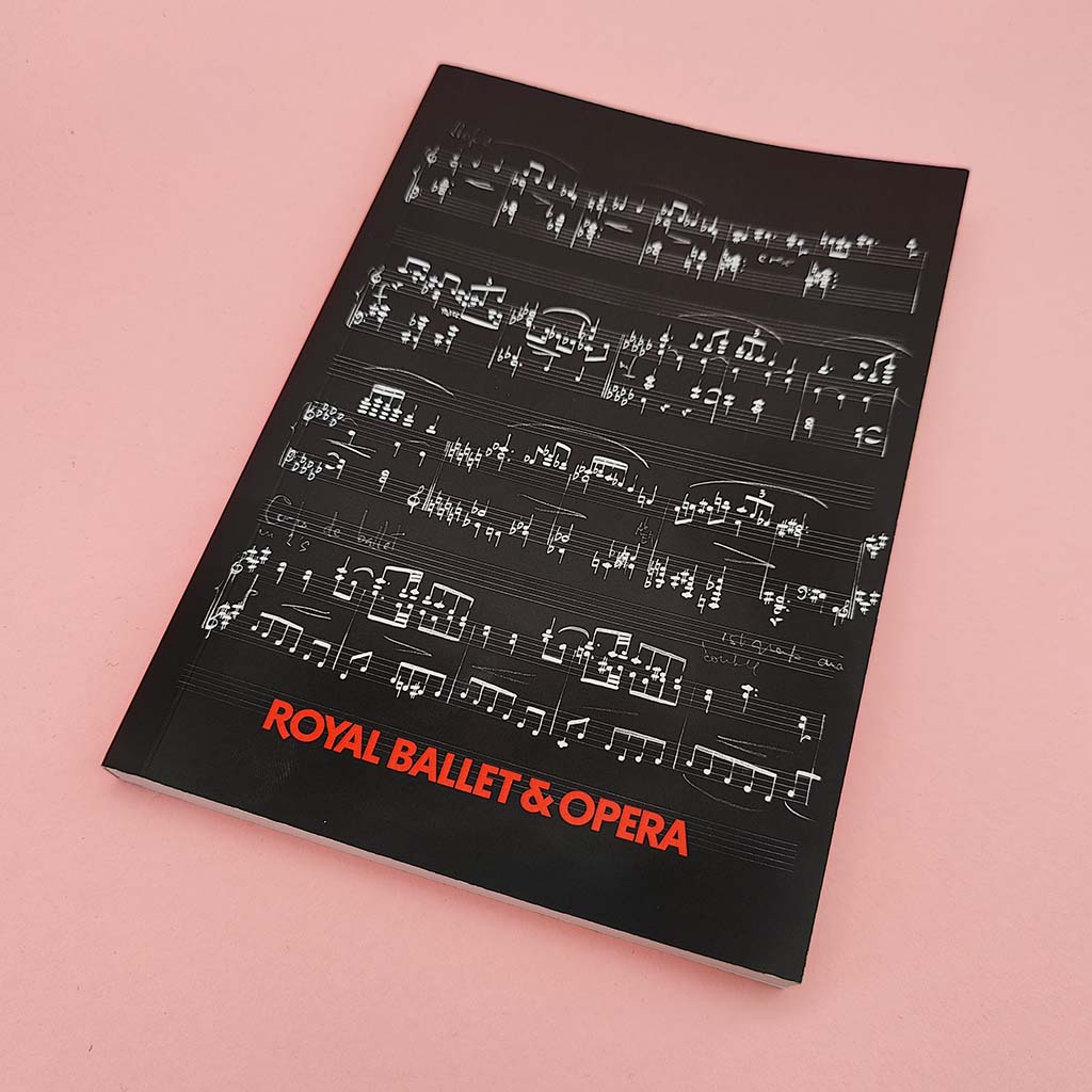 A softcover A5 notebook with red text Royal Ballet & Opera, featuring a black background with white musical notation and the title in red text at the bottom.