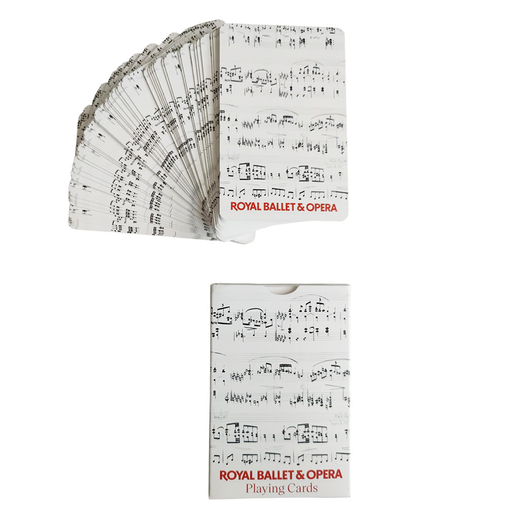A deck of Royal Ballet &amp; Opera playing cards shown fanned out above its box, with a white card face printed in black musical notation and red title text.