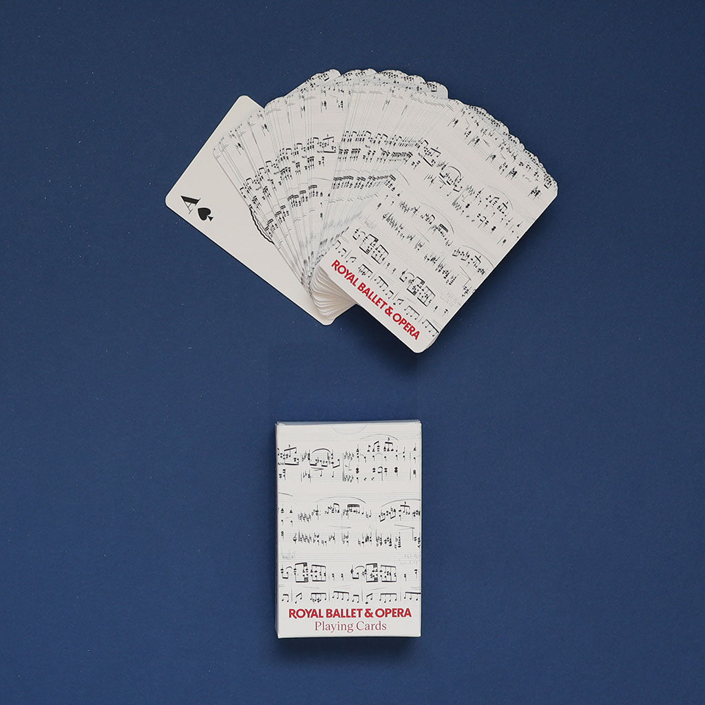 A deck of Royal Ballet &amp; Opera playing cards displayed on a dark blue background, with several cards fanned out above the box and one black ace card visible.