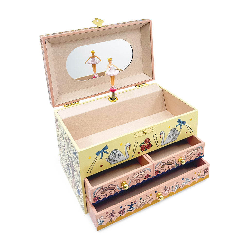 A decorative wooden music box jewellery box with an open lid showing a mirror and ballerina figurine, decorated with swans, bows, and musical notes in pastel colours, with two drawers and gold-tone knobs.