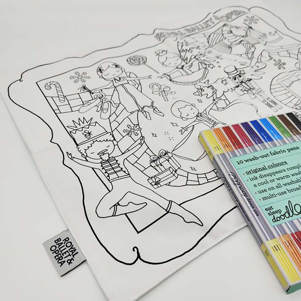 white fabric placemat with Nutcracker illustrations and colouring pens