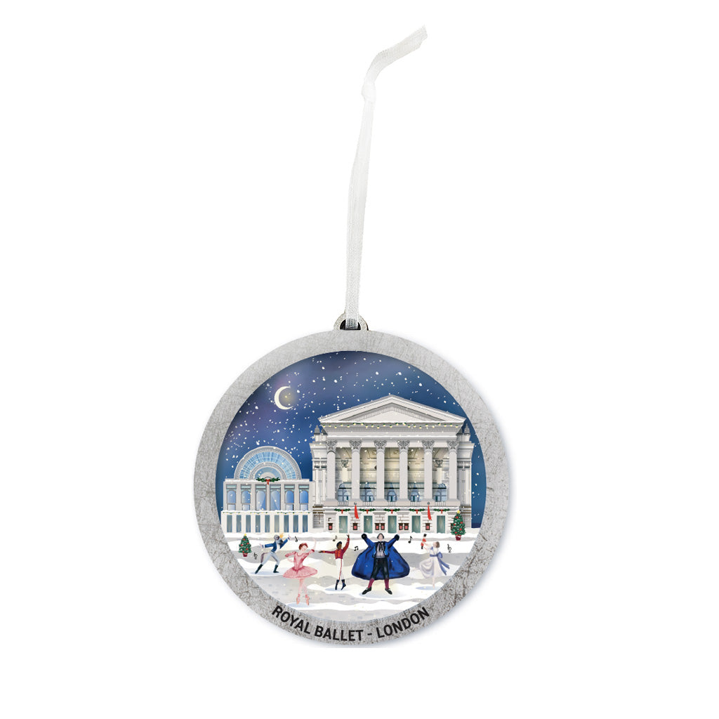A round silver and blue wooden Christmas decoration featuring an illustration of the Royal Opera House in London under a starry night sky, with dancers in the snow in front. The ornament has a silver hanging loop and the words 'ROYAL BALLET - LONDON' printed along the bottom edge.