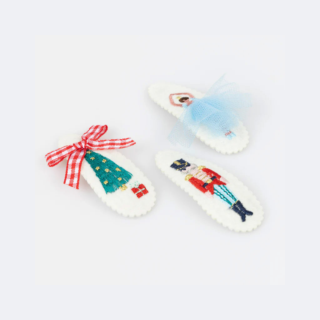 Decorative hair clips with Nutcracker designs on a white background