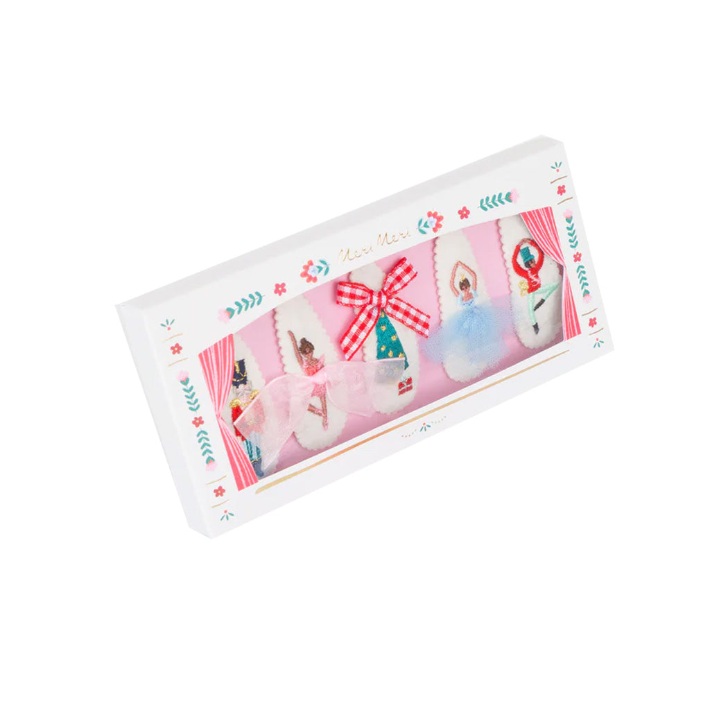 Decorative box of nutcracker hair clips featuring characters from the ballet and a bow on a white background