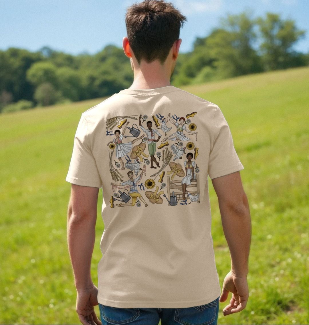 Person wearing an oat coloured t-shirt with a colourful Fille mal gardee ballet illustration on the back, standing in a grassy field.