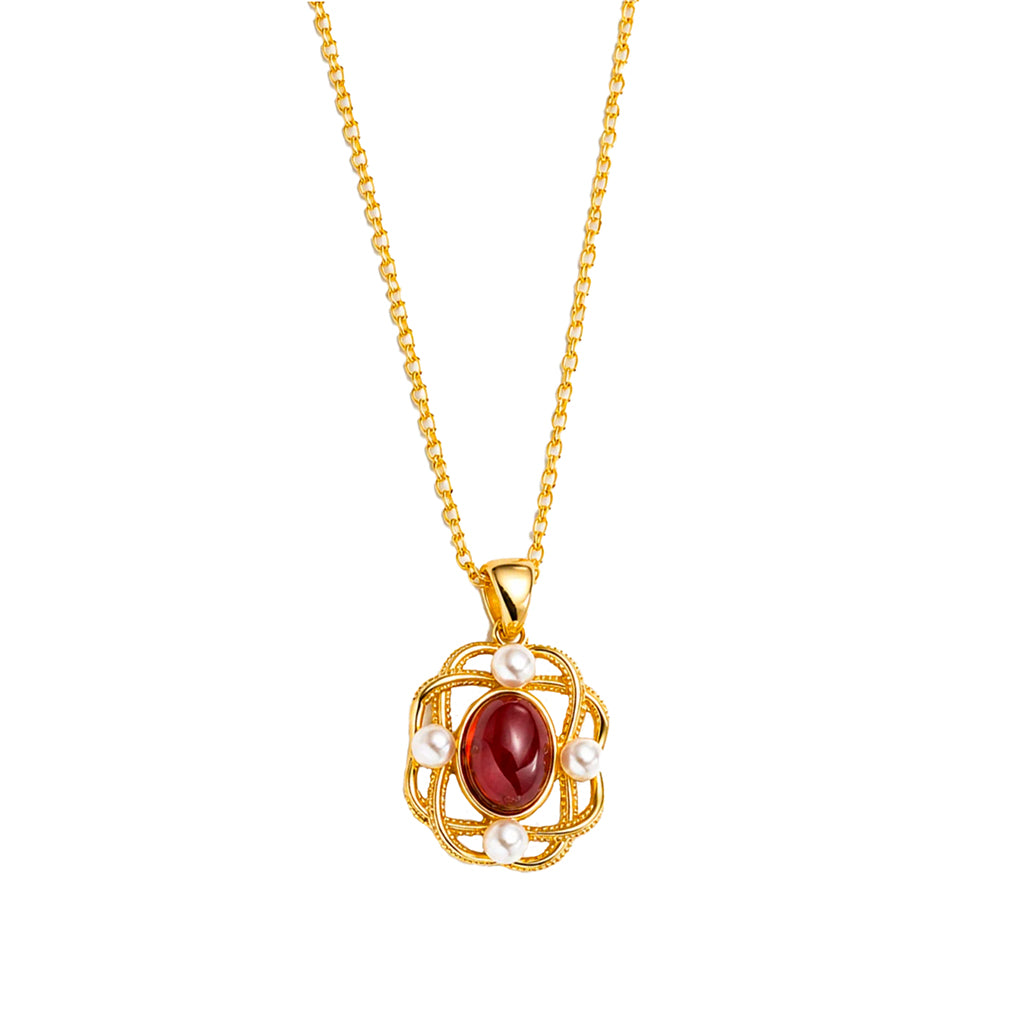 A gold chain necklace with a decorative pendant featuring a central oval red garnet gemstone and small white pearl accents, shown on a plain white background.