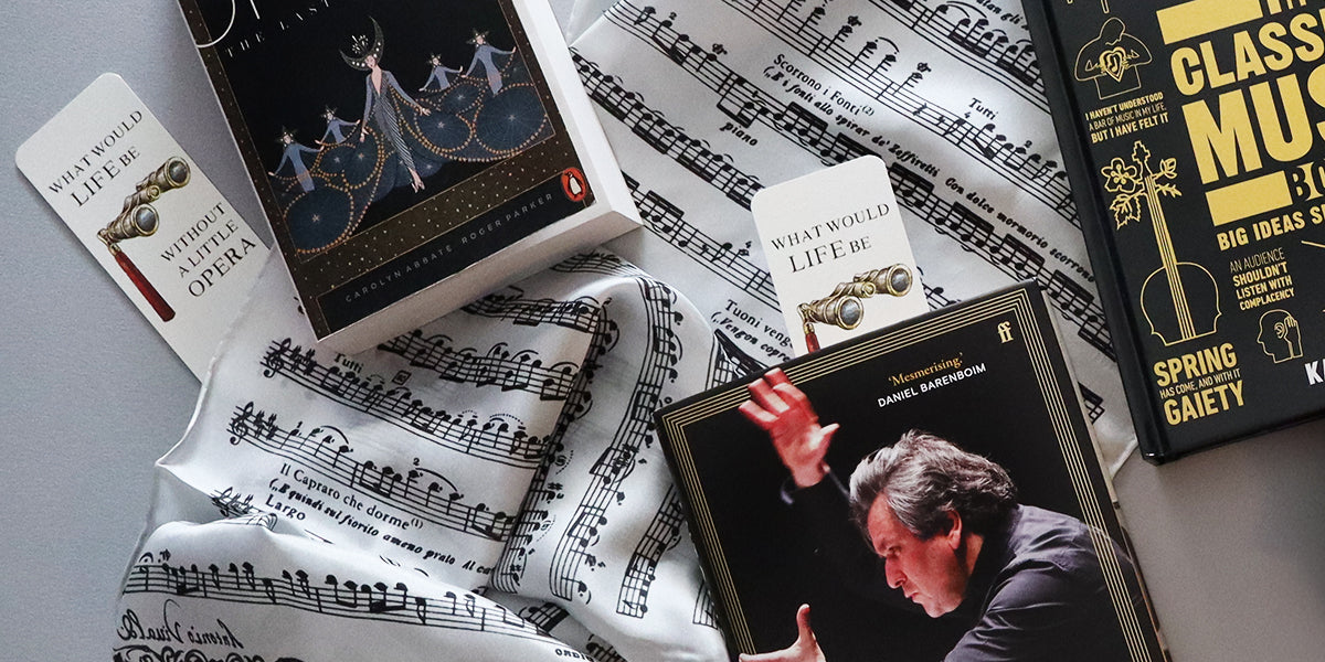 A styled flat-lay of several books and a scarf featuring sheet music. Visible items include a book titled 'Classical Music' by Spring Gaitey, a book mark titled 'What Would Life Be Like Without Opera', arranged on top of printed musical notation.