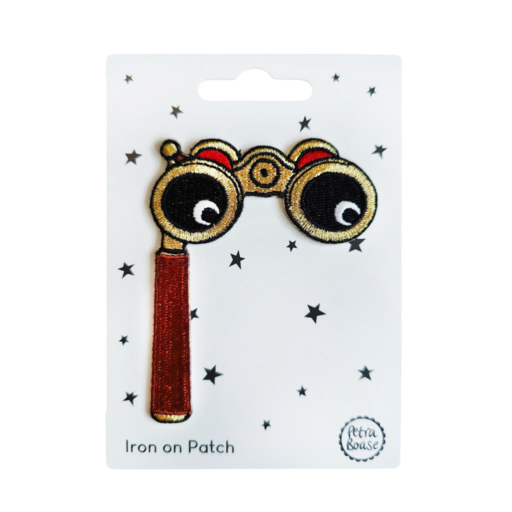 Iron on patch of opera glasses with eyes on a white card with star patterns