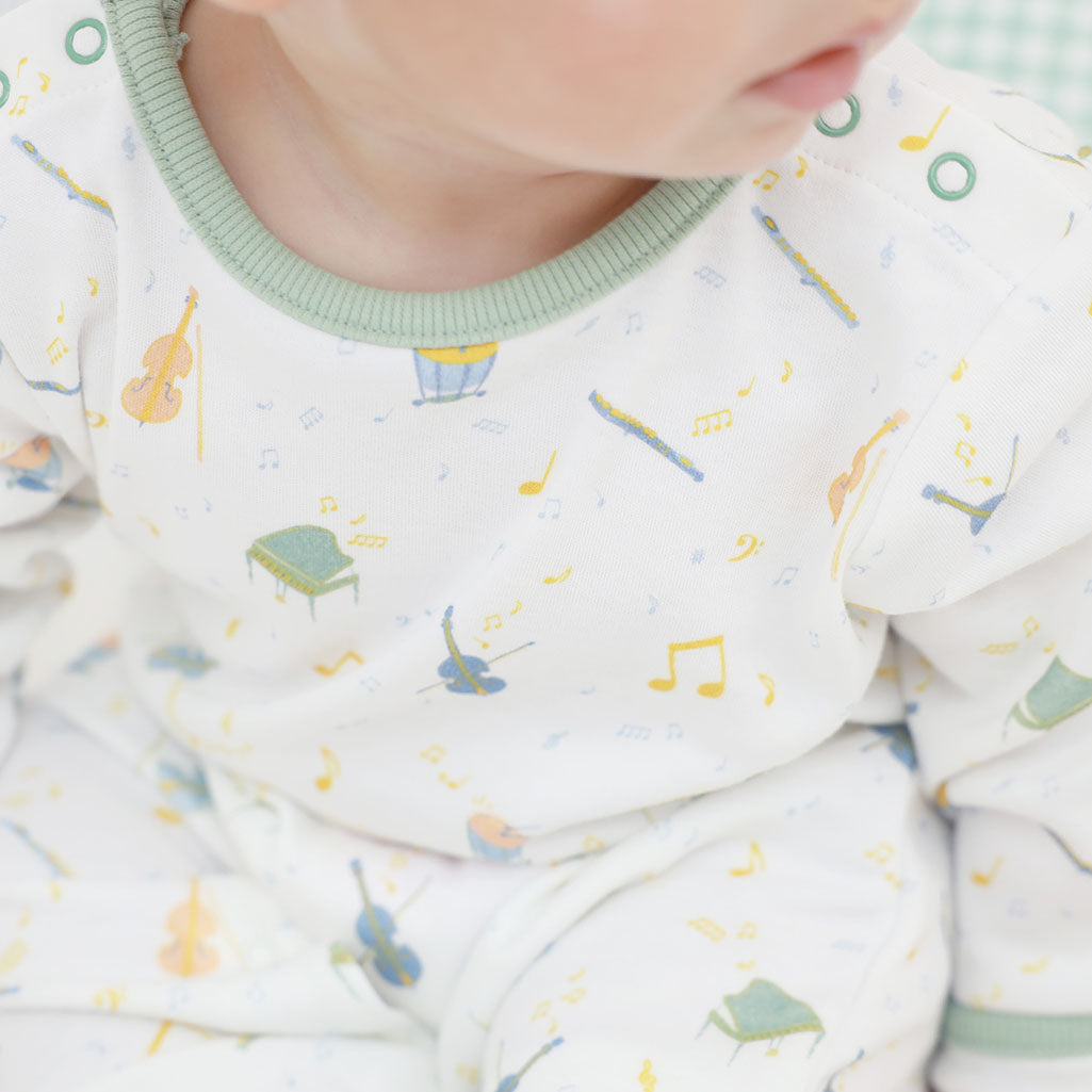Baby wearing musical instrument pattern baby grow