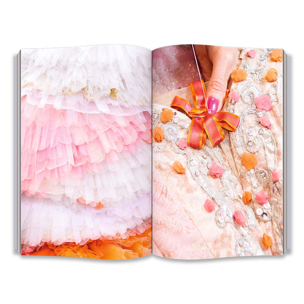 Open book showing a hand sewing a costume and a colourful tutu tree