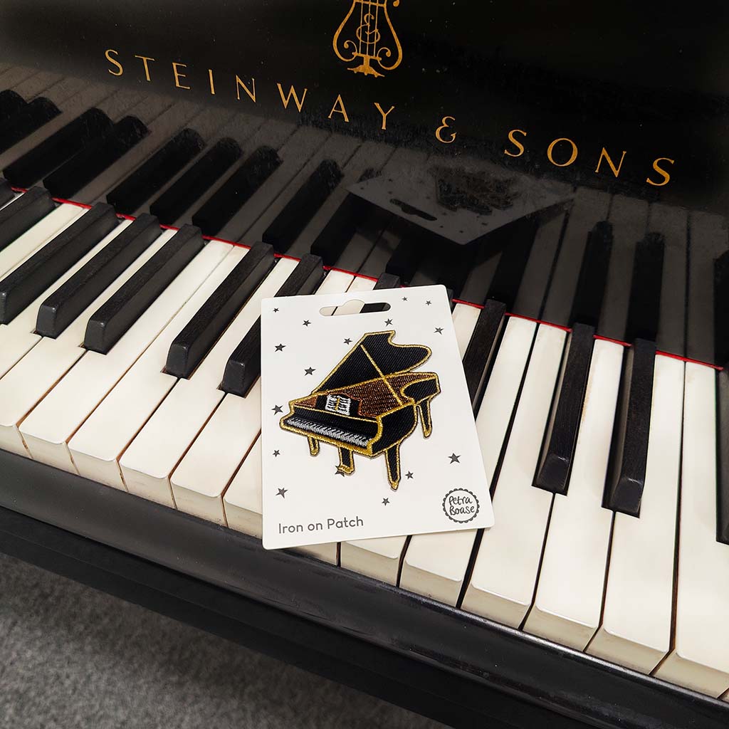 Steinway &amp; Sons piano with a patch featuring a grand piano design on the keys.