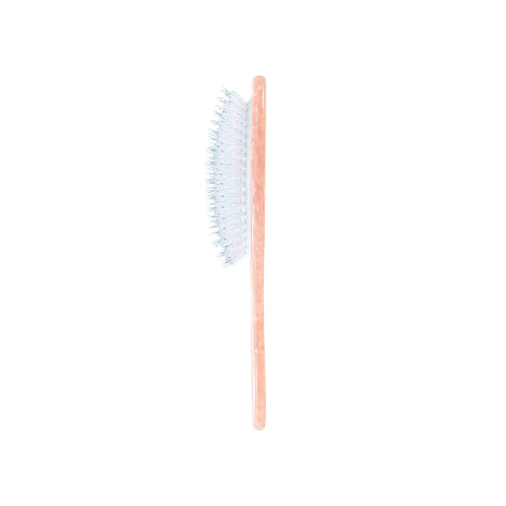 Side view of Pink Hairbrush with soft bristles on a white background