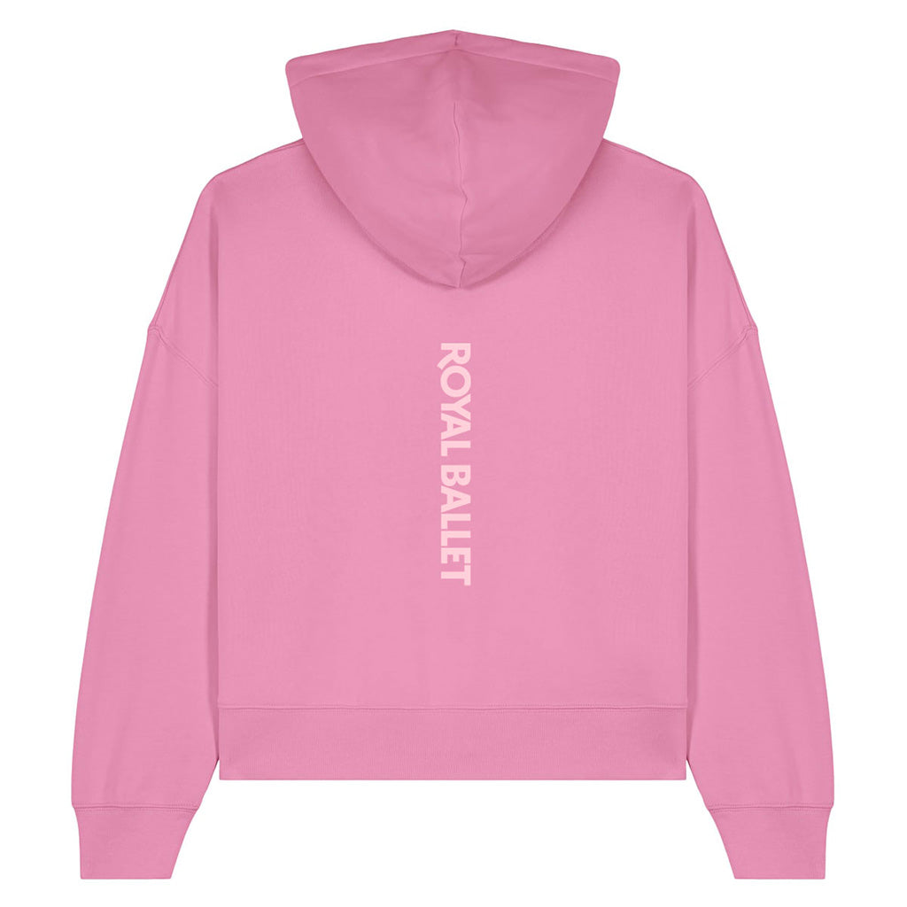 A pink cropped hoodie shown from the back, featuring the words 'ROYAL BALLET' printed vertically in white text down the center back.
