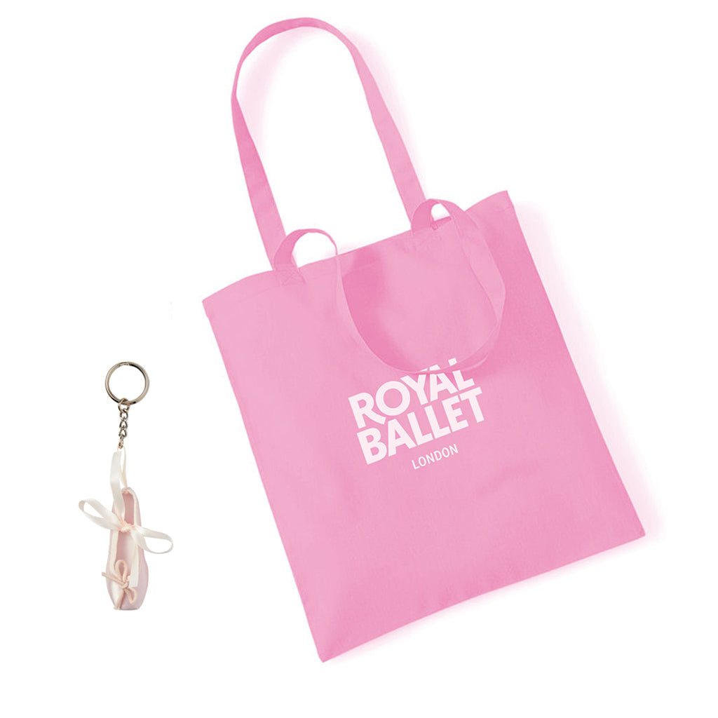 Pink tote bag with 'Royal Ballet London' text and ballet shoe keyring on a white background
