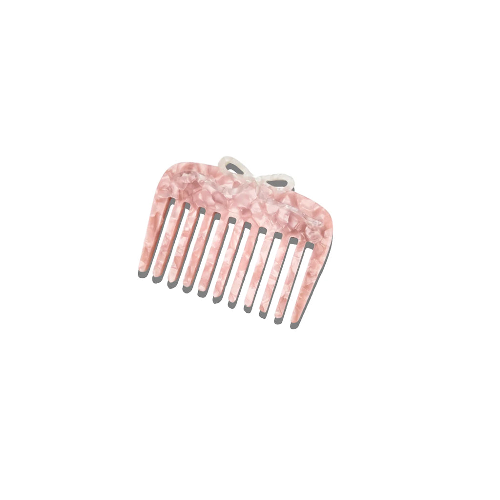 Pink ballet Bow comb on white background
