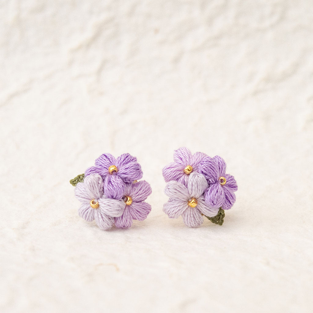 purple micro crochet floral earrings on a textured white background