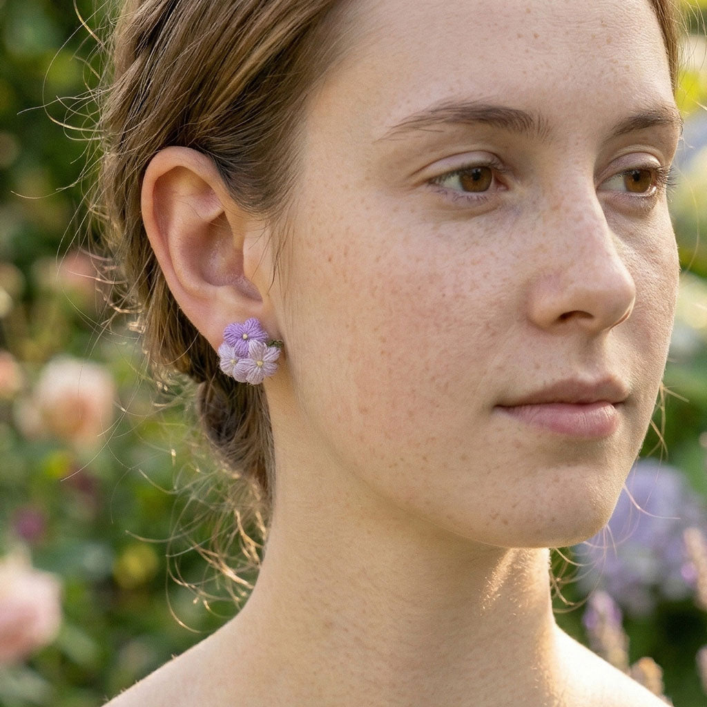 model wearing purple micro crochet floral earrings with a green 
background