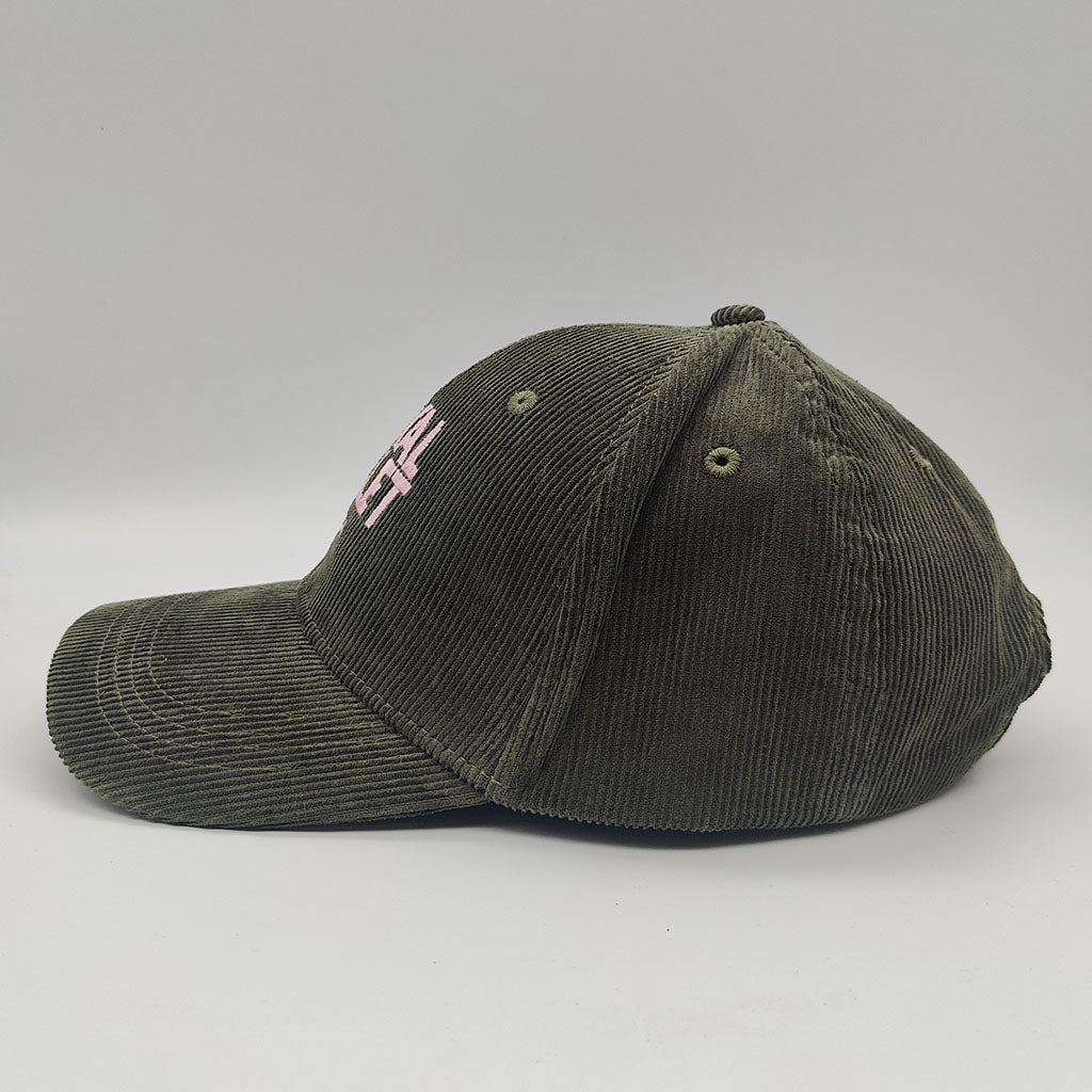 Green corduroy cap with a pink logo on a light gray background