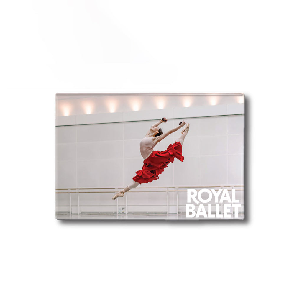 A rectangular Royal Ballet branded fridge magnet of a ballerina in a red dress mid-leap, with the Royal Ballet logo in the lower right of the photo.