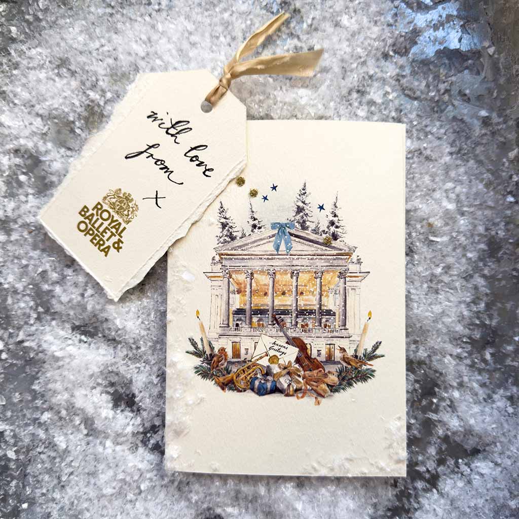 Christmas card with a festive design featuring th Royal Opera House and decorative elements, on a textured surface.