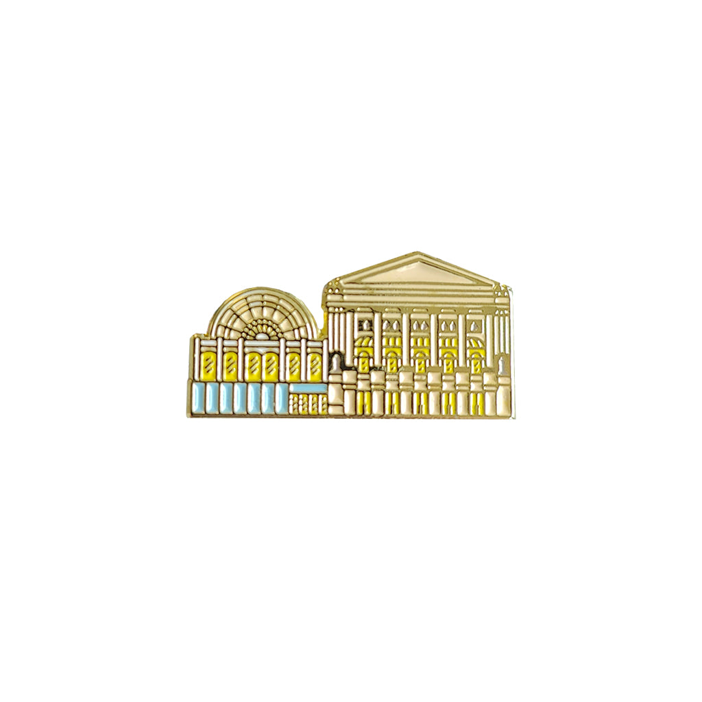 Gold-coloured architectural pin badge of the Royal Opera House on a white background
