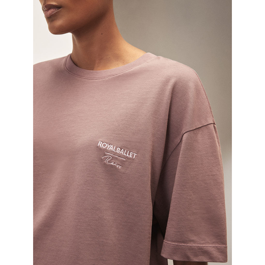 Person wearing a mauve t-shirt with &#39;Royal Ballet Reiss&#39; logo