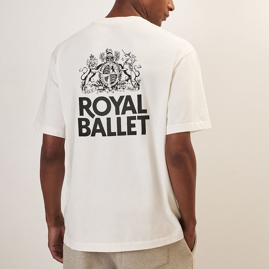 Person wearing a white &#39;Royal Ballet&#39; t-shirt with a logo on the back against a plain background